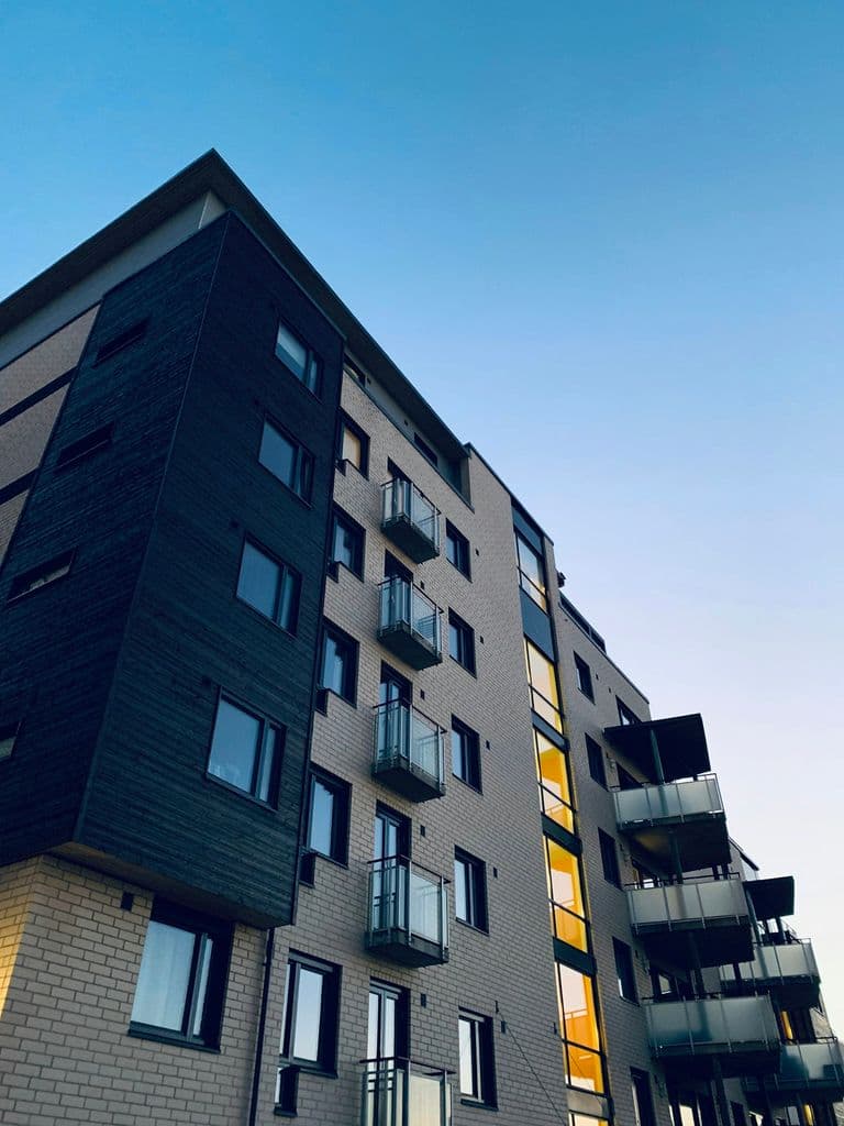Calle arbolada con torres de apartamentos en Naco